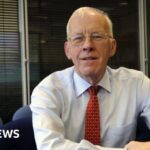 Sir Ian Wood in a shirt and tie, smiling