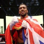 Anthony Joshua celebrates with the Union Jack draped over him
