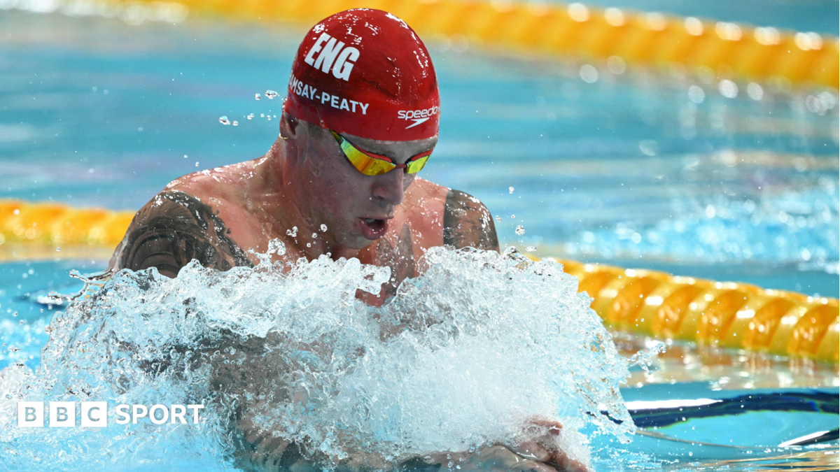 Adam Ramsay-Peaty, wearing a red Speedo swimming cap and goggles, swims in the pool during the 50m men's breaststroke