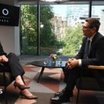Andy Burnham and Laura Kuenssberg sit opposite one another on brown chairs with a coffee table between them, on top of which