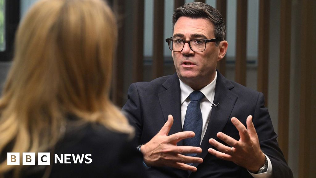 Burnham gestures as he speaks to the BBC's Laura Kuenssberg, who sits with the back of her head to camera