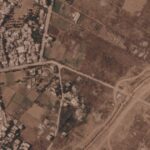This satellite image from Planet Labs PBC shows a section of an earthen barrier being built by the Israeli military, right