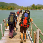Backpackers walking over a bridge