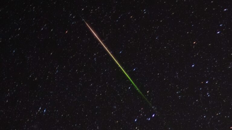 a streak of light crosses through the night sky
