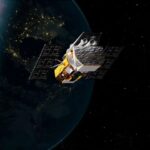 illustration of a gold and silver spacecraft in earth orbit at night
