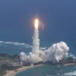 A white and yellow Japanese rocket launches the Kaguya spacecraft to the moon on Sept. 13, 2007