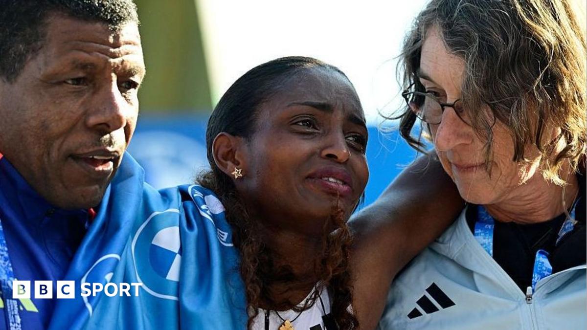 Ethiopia's Tigst Assefa (C) is helped off the track after crossing the finish line to win the women's race of 52nd Berlin