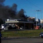 Smoke rising from a petrol station beside a road