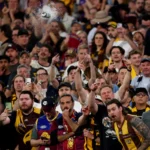 A can is seen hurtling towards AFL umpires after the Hawks' AFL final loss to Brisbane