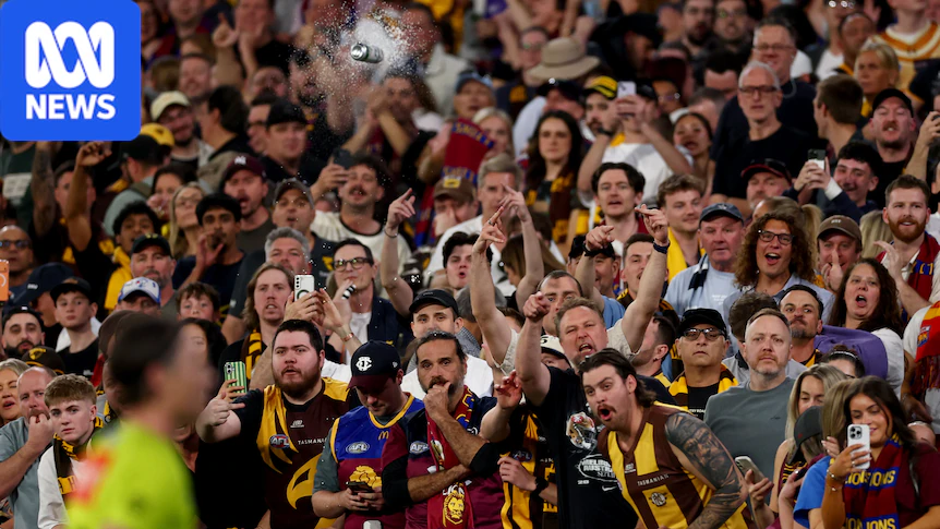 A can is seen hurtling towards AFL umpires after the Hawks' AFL final loss to Brisbane