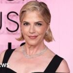 US actress Selma Blair smiles during event arrivals while wearing diamond necklaces and black strapped gown