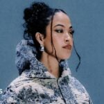Jazzy, pictured wearing a blue and white jacket embroidered with country scenes. The 30-year-old has her dark hair tied back