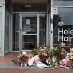 Floral tributes are placed outside the offices of Australian lawmaker Helen Haines who was critically wounded in a