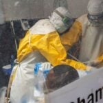 Medecins Sans Frontieres (MSF) doctors treat a patient inside the Kitatumba Ebola treatment center, as aid agencies
