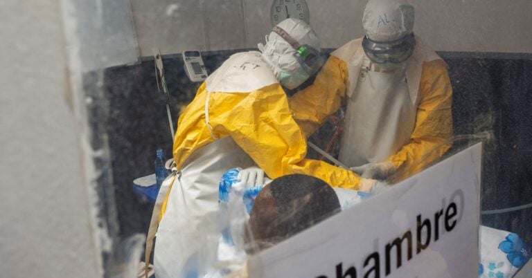 Medecins Sans Frontieres (MSF) doctors treat a patient inside the Kitatumba Ebola treatment center, as aid agencies
