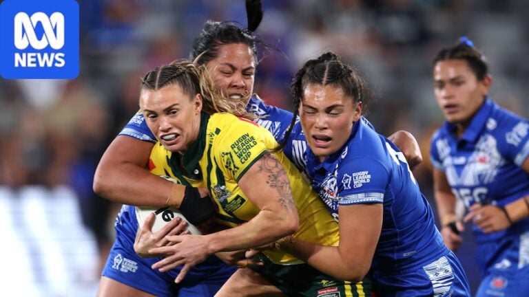 Female rugby league player trying to break free from two defenders