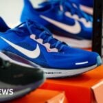 Nike trainers in a shop displayed on top of a Nike shoe box