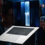 The MacBook Pro with PROLED XDR display on a pedestal in crowded press area