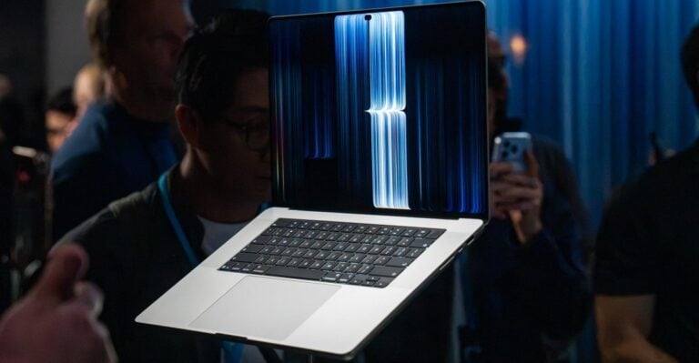 The MacBook Pro with PROLED XDR display on a pedestal in crowded press area